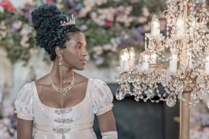 Behind the scenes of a Bridgerton Netflix filming setup at Newark Town Hall, showing a lady in ballroom attire next to a lamp.