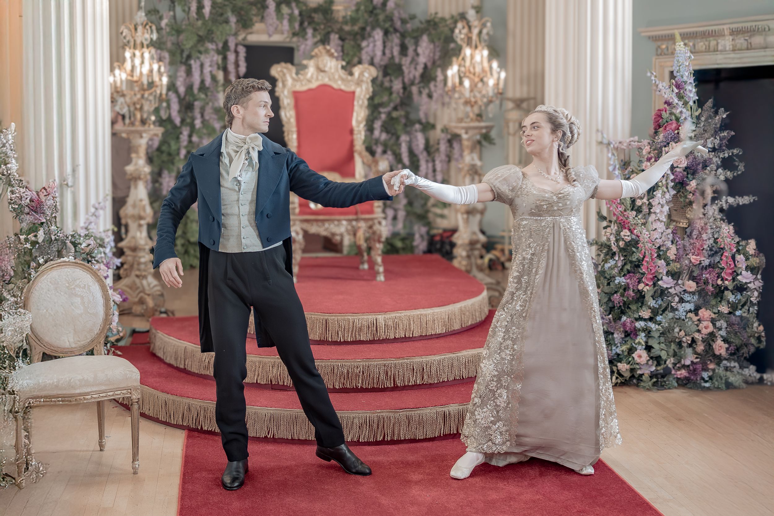 Behind the scenes of a Bridgerton Netflix filming setup at Newark Town Hall, showing a couple in front of the royal throne dancing.