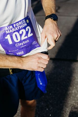 Runner wearing bib number 1022 at Air Force Marathon adjusts race gear before the start.