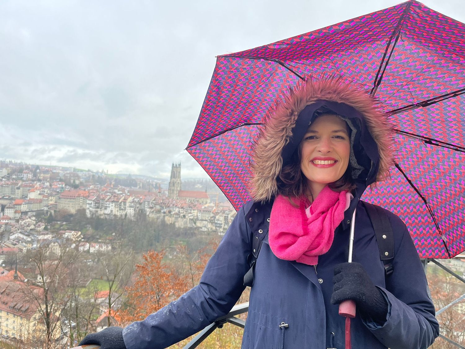 A series of photos shows someone holding a pink umbrella while enjoying an autumn day overlooking a scenic cityscape.