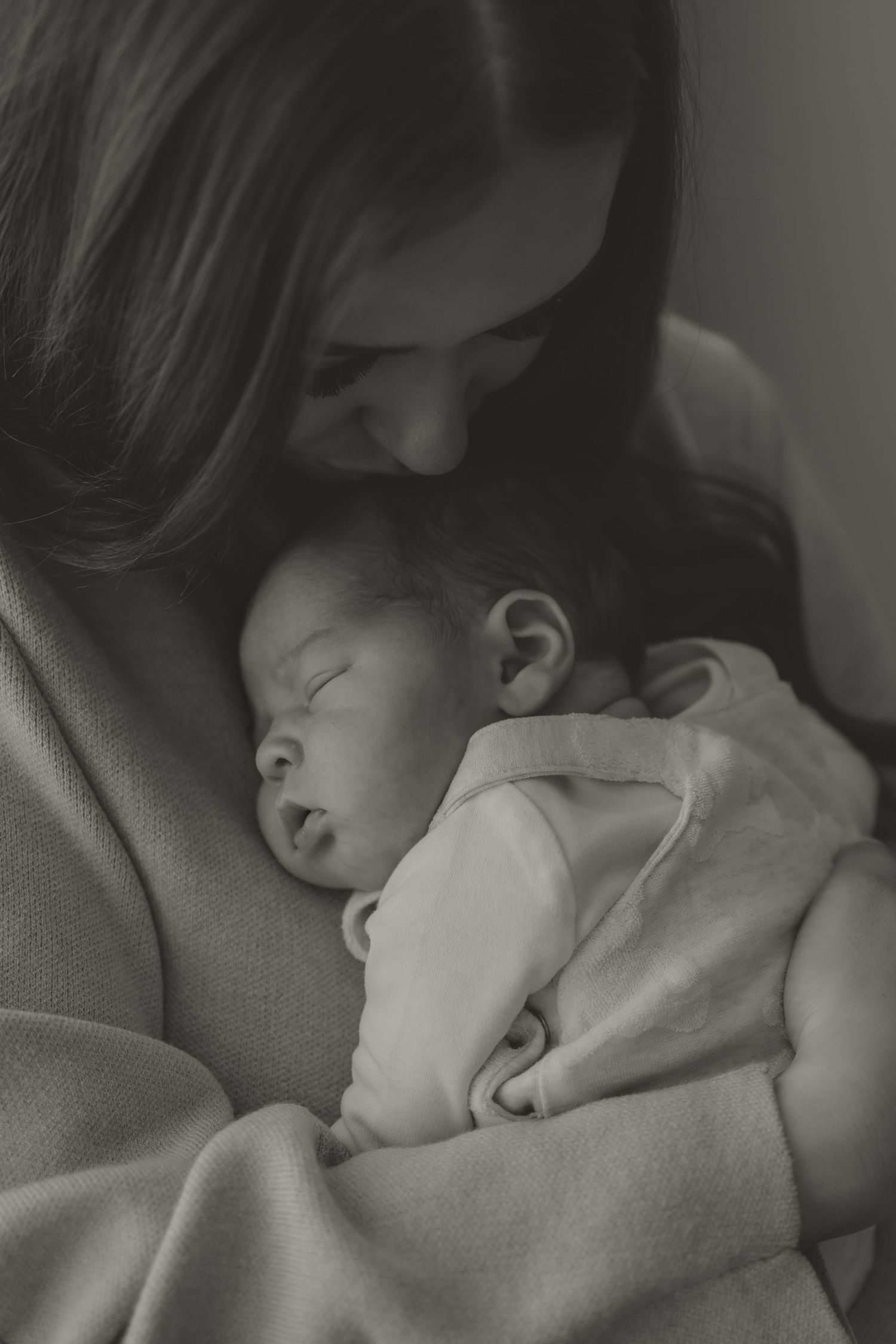 Intimate black and white photos of tender moments between parent and sleeping baby.