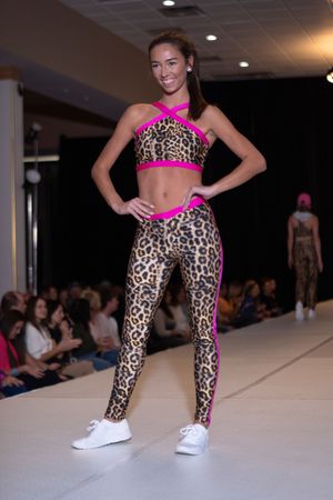 Pink and leopard print activewear ensemble showcased on white runway.