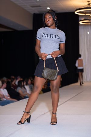 Grey Paris t-shirt paired with black shorts displayed during fashion show.
