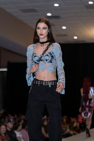 Edgy runway look featuring light blue lace crop top with black pants and choker necklace.