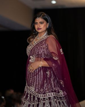 Luxurious burgundy Indian lehenga with intricate silver embroidery and sheer dupatta.