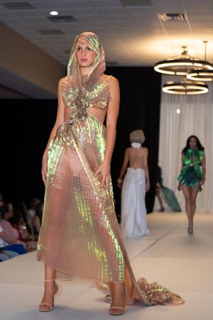 Shimmering iridescent gown with cutouts creates dramatic effect on fashion runway.