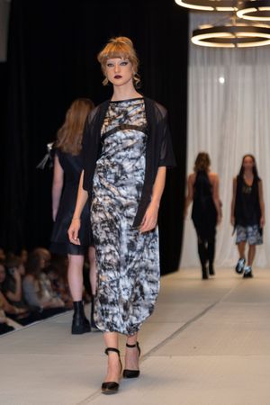 Marble print midi dress paired with sheer black overlay creates elegant runway look.