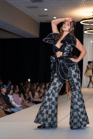 Evening gown with black and white floral pattern displayed during runway fashion show.