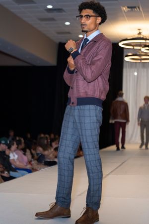 Preppy look featuring plaid pants, burgundy sweater and dress shirt on fashion runway.