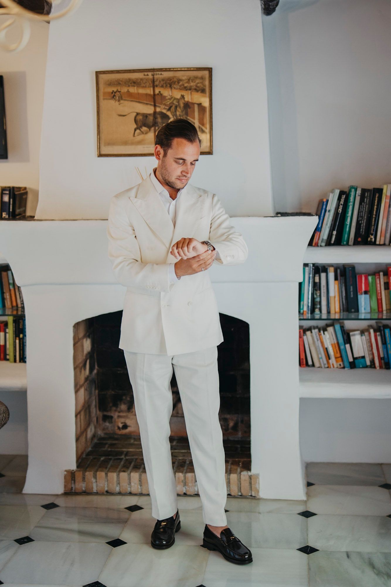 Multiple shots of a person in white formal attire posing in a room with bookshelves and artwork.