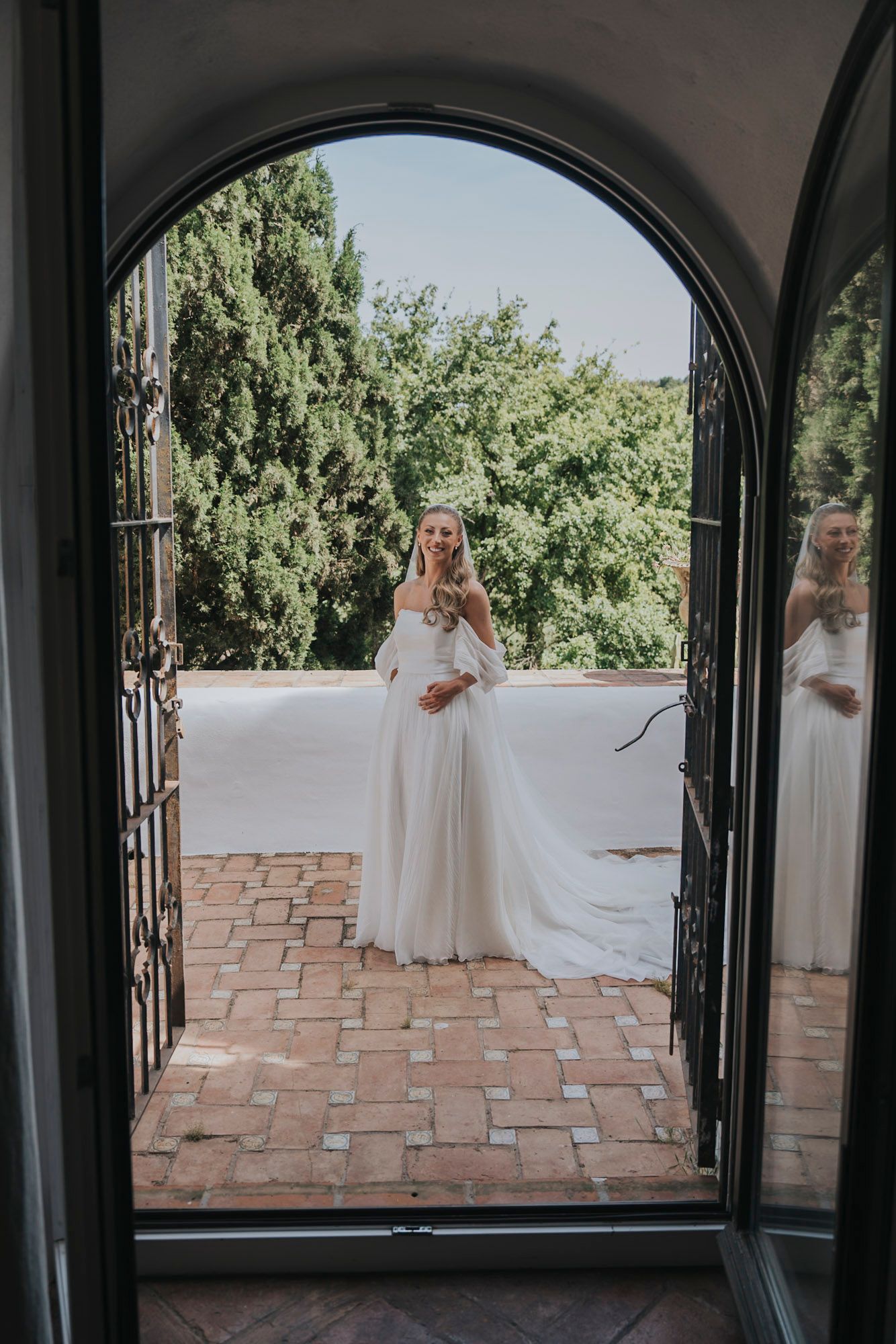Series of arched doorways framing views of a terracotta tiled patio and garden.