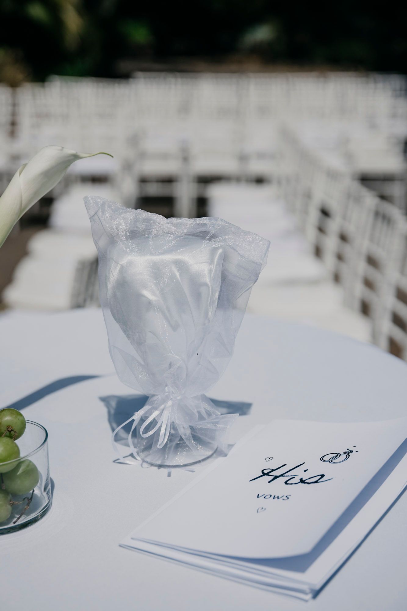 Wedding favors and place cards arranged elegantly on a white table with delicate tulle wrapping.