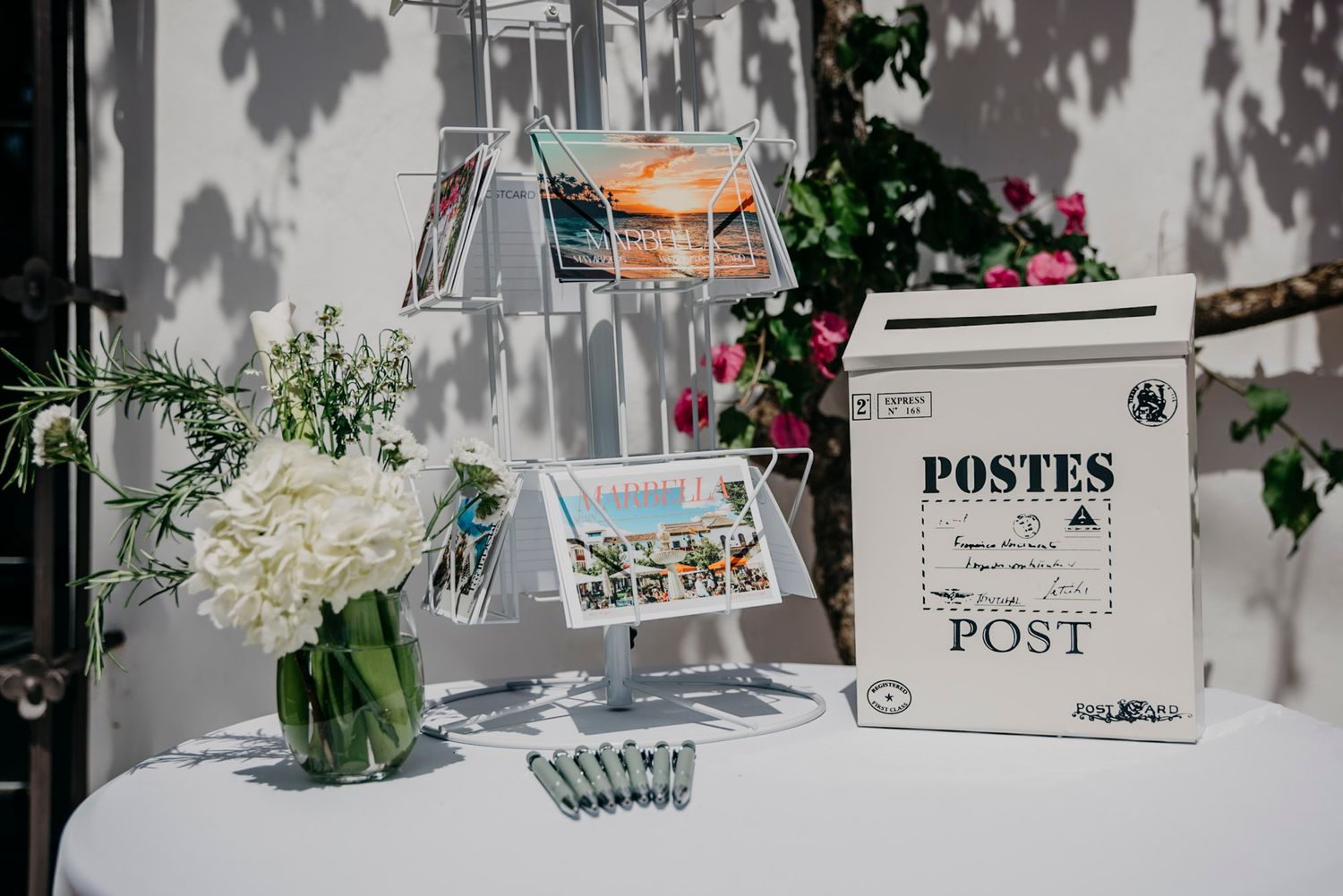 Vintage-style wedding decor featuring rustic white mailboxes and floral arrangements on a display table.