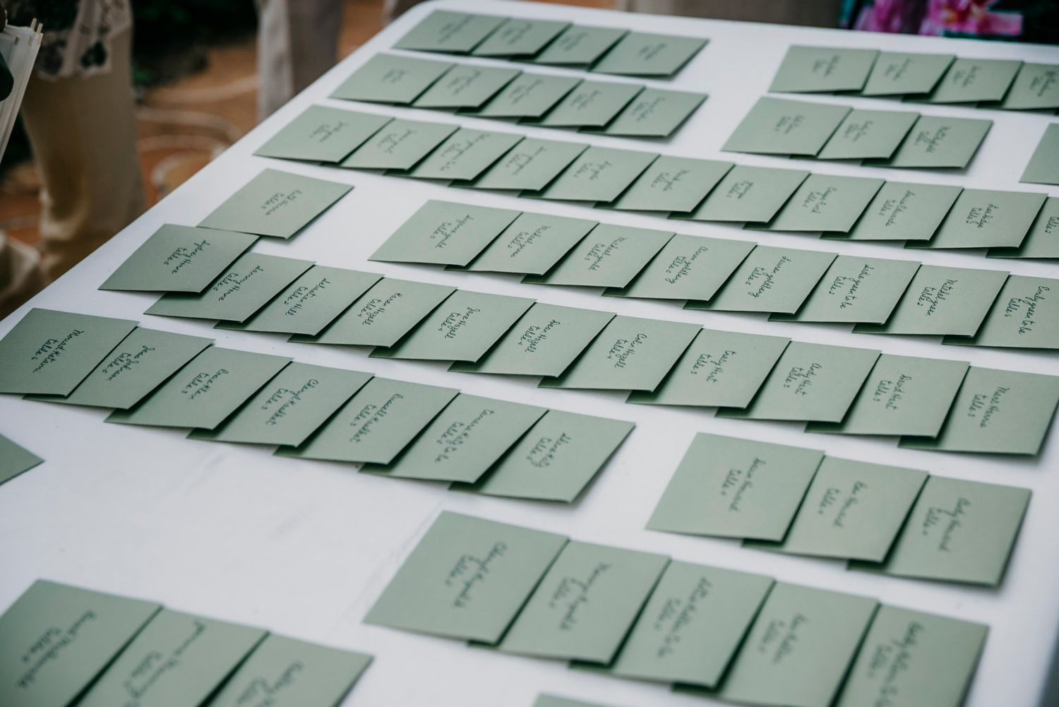 Wedding seating cards arranged neatly on display table.