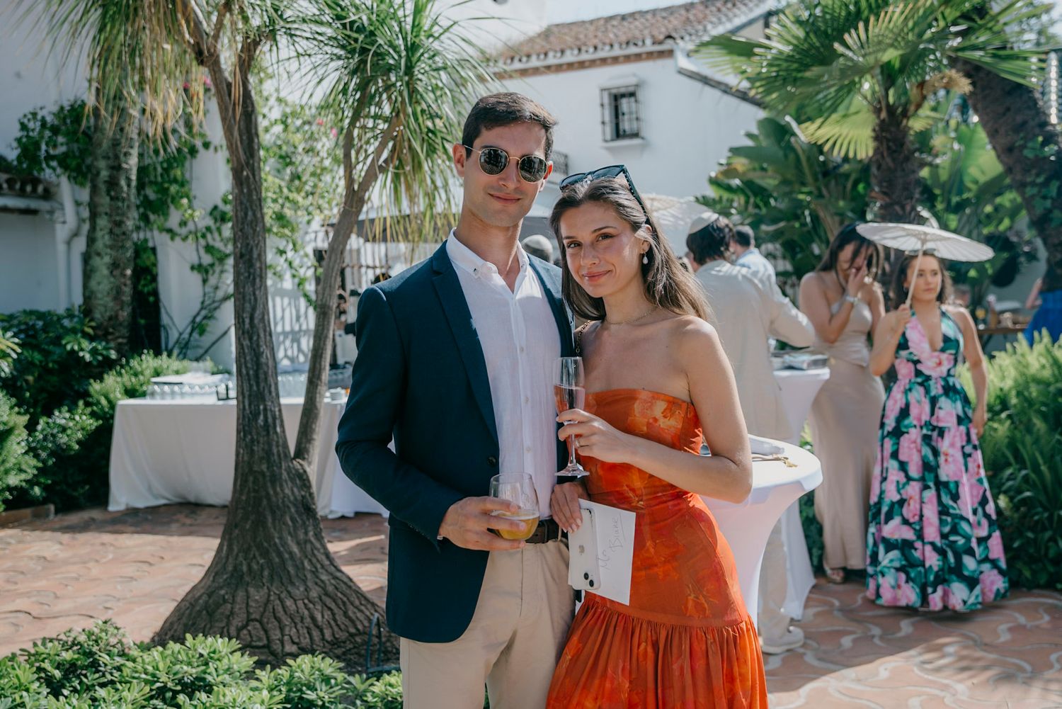 Mediterranean wedding venue with palm trees and white stucco walls on a sunny day.