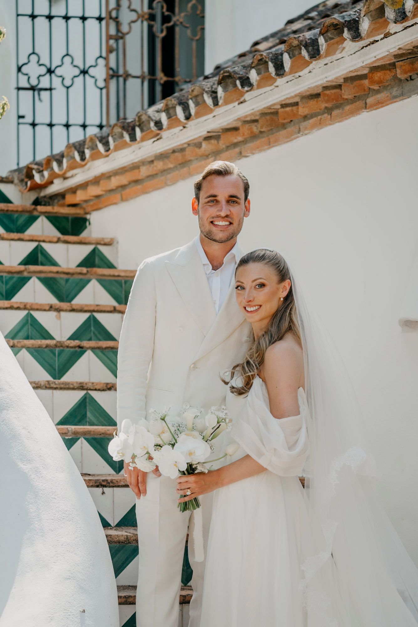 Wedding couple portraits against a decorative wall with green and white geometric patterns.