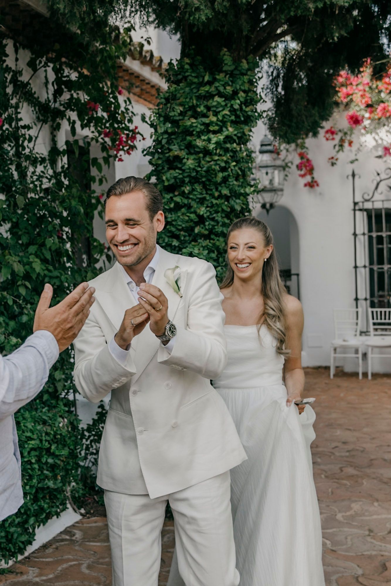 Celebratory moment at outdoor wedding with ivy-covered walls.