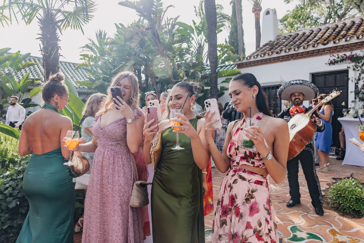 Wedding reception guests mingling and celebrating in an outdoor garden setting.