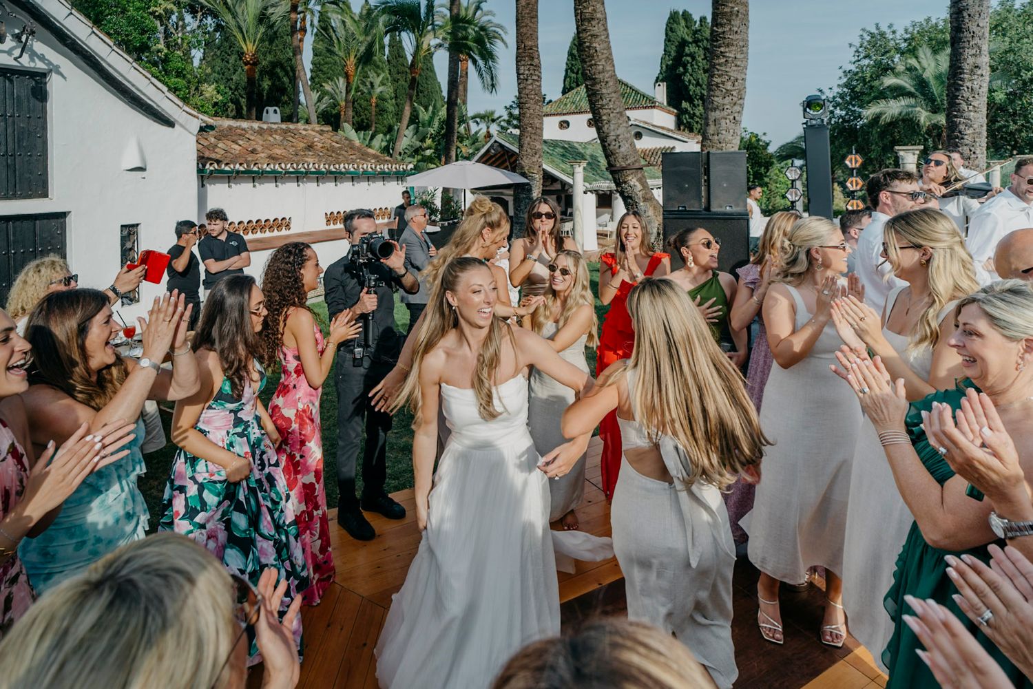 Tropical wedding venue with palm trees and white buildings under bright blue skies.