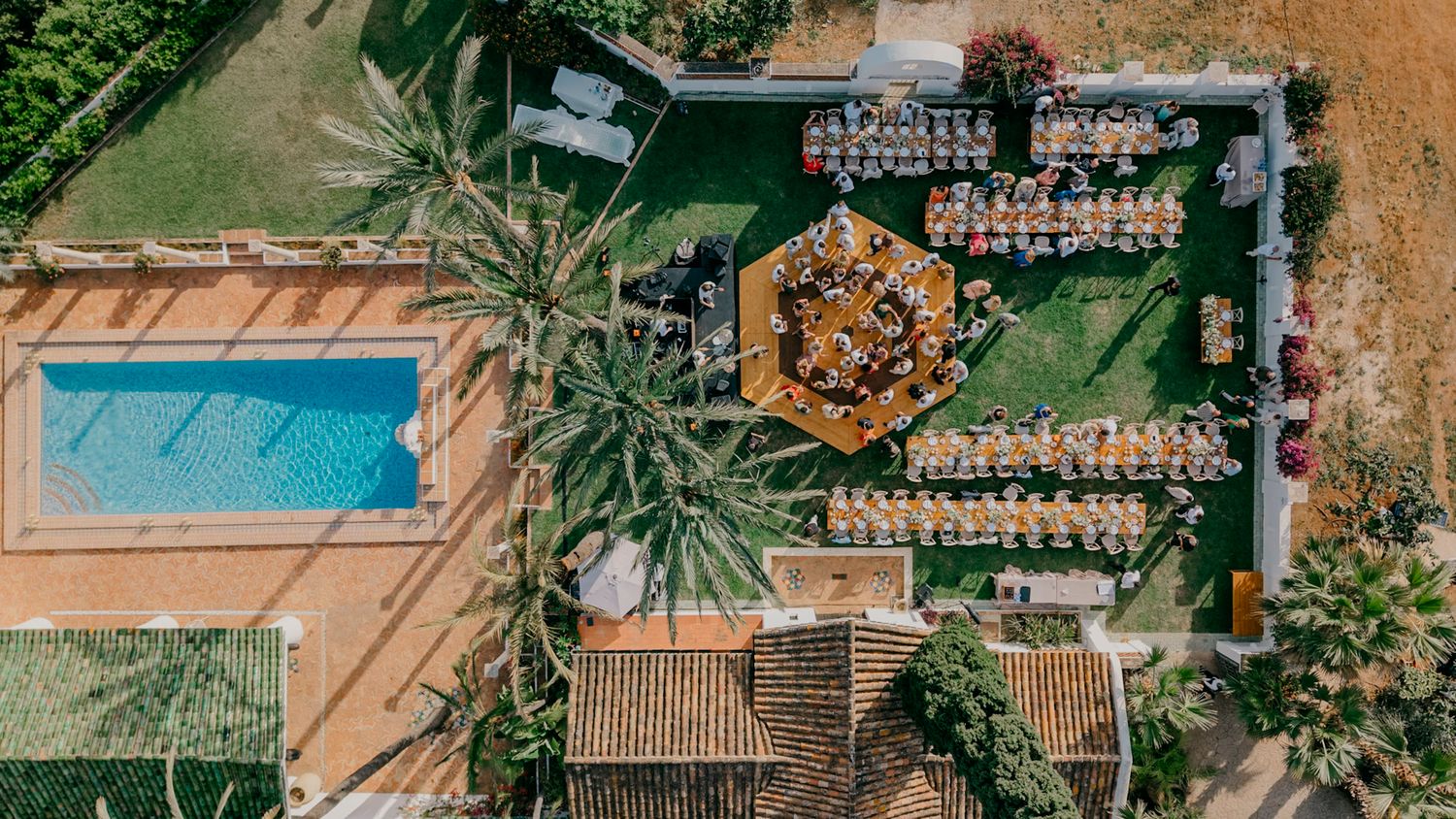 Aerial view of a luxury resort property with swimming pools and palm trees in a tropical setting.