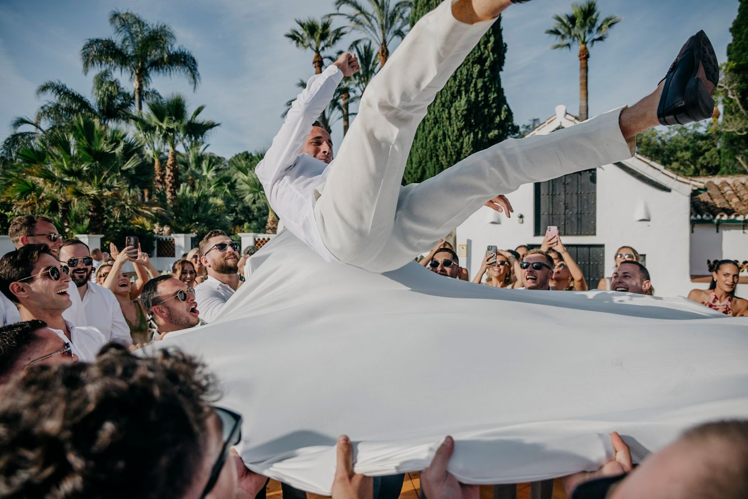 Celebratory moments captured at an outdoor wedding with palm trees in the background.