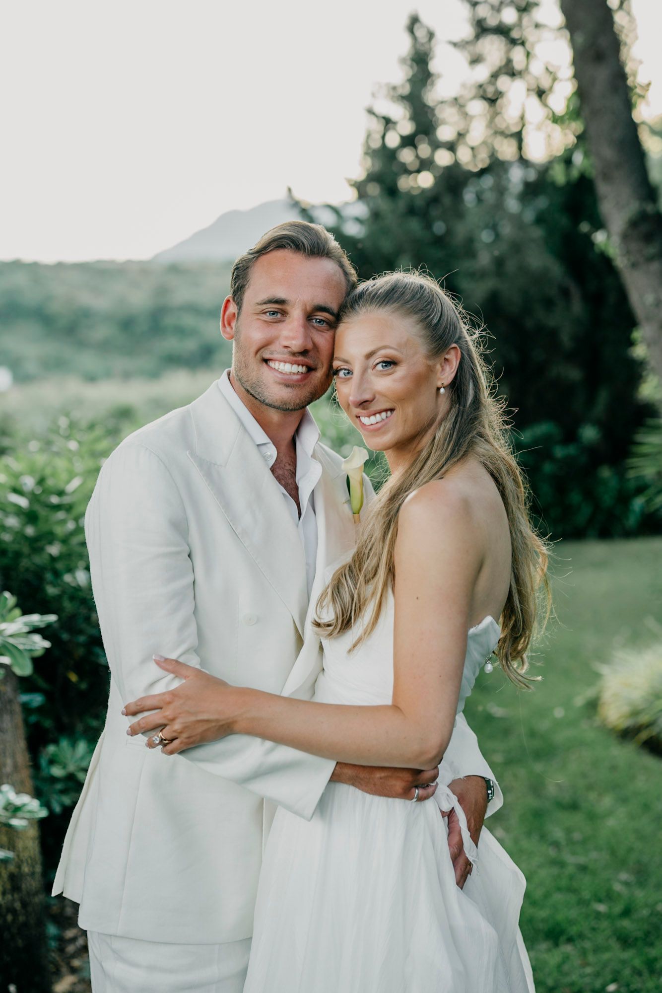 Romantic couples portraits in an elegant garden setting with natural sunlight.