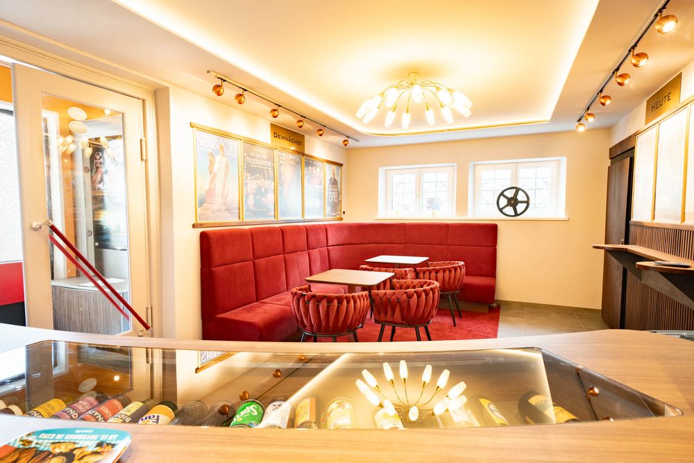 Modern hotel lobby interior with warm lighting, red seating, and a sleek contemporary design showcases elegant furnishings.