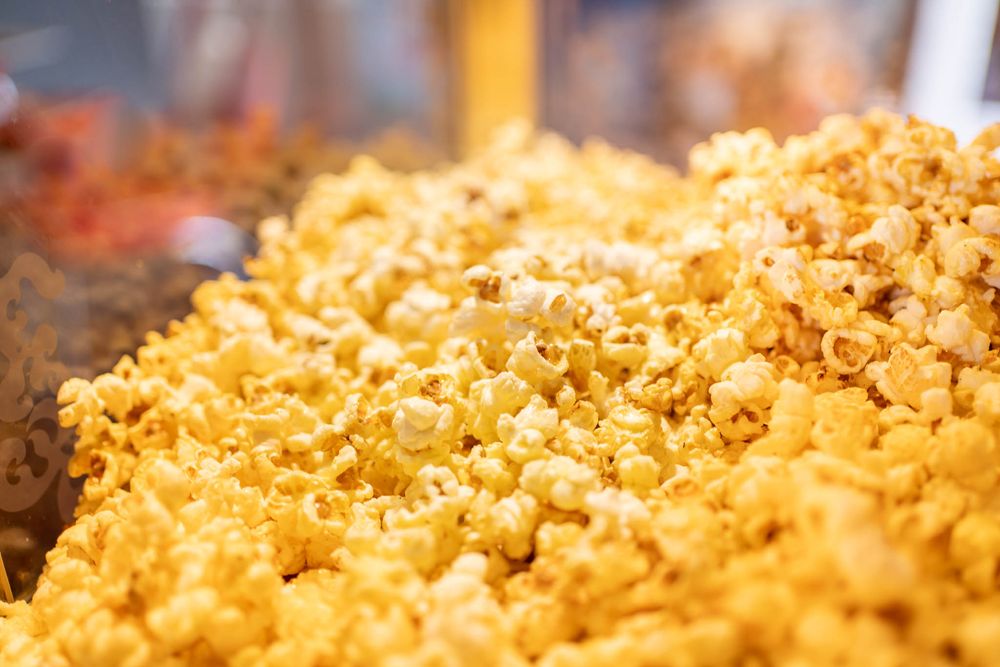 Golden caramel popcorn kernels in a close-up macro shot showing detailed texture and warm lighting.