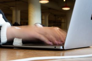 Blurred motion of hands typing on a computer