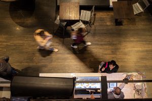 People walking through a food market from above, blurred motion.