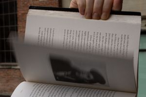 Open book flipping through, showing motion. Fingers holding book open.