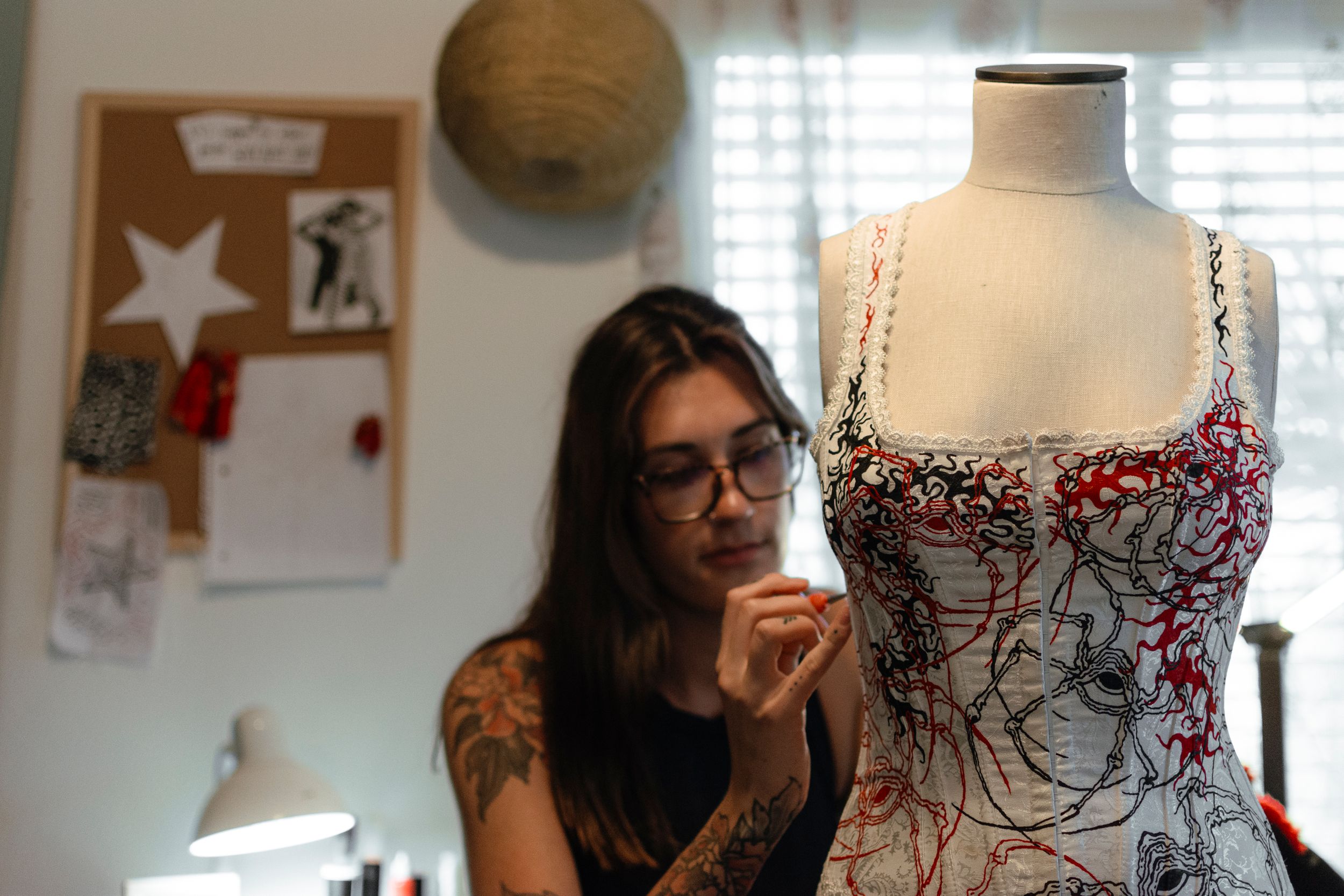 Woman painting onto a corset, creating a piece of fashion