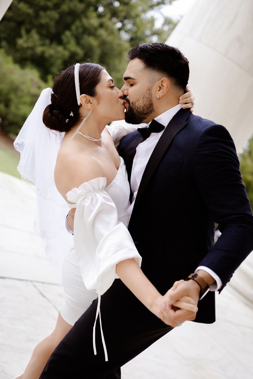 A romantic wedding couple shares an intimate kiss in a series of artistic black and white photographs.