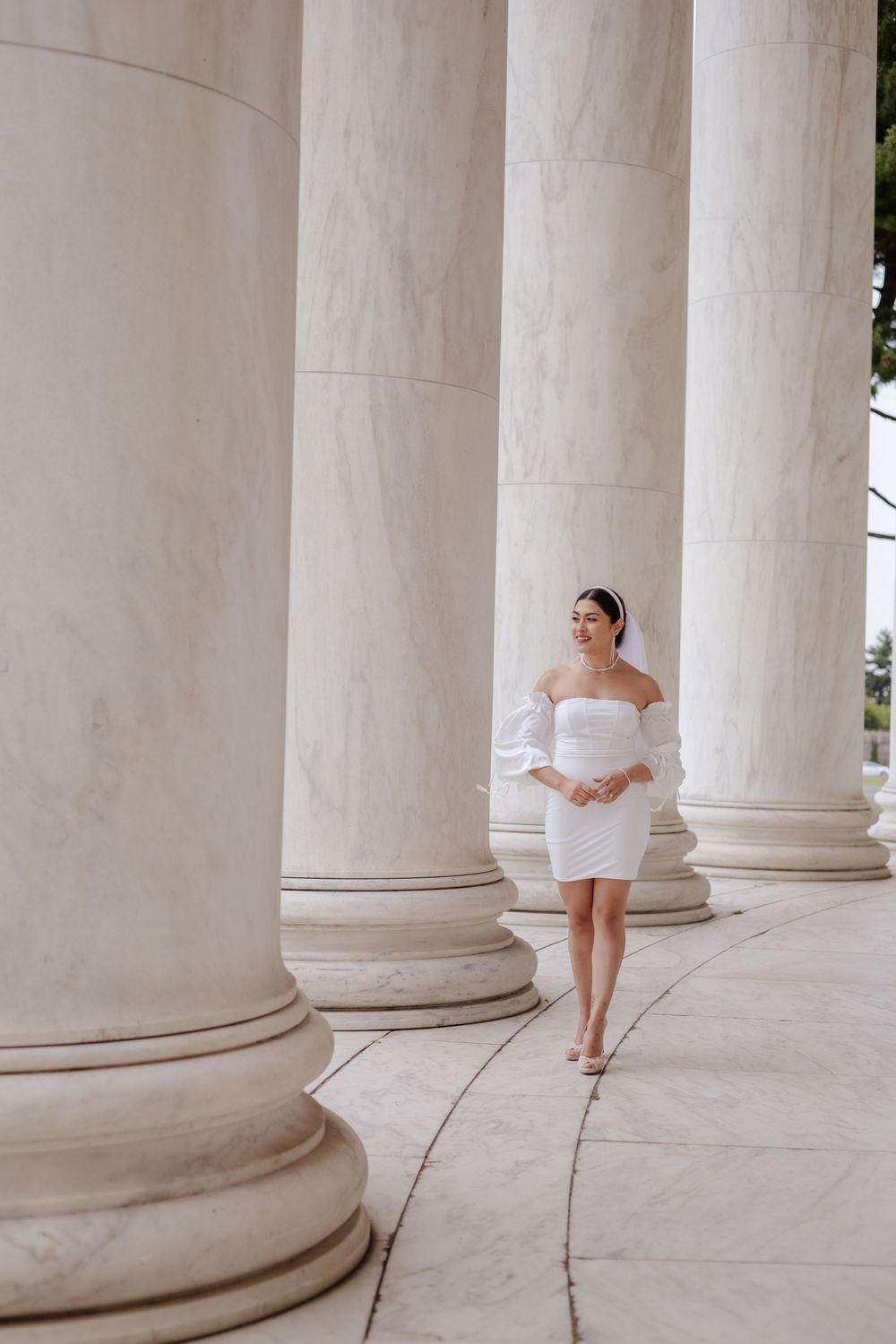 A sequence of photos showing someone in a white dress posing elegantly between classical white stone columns.