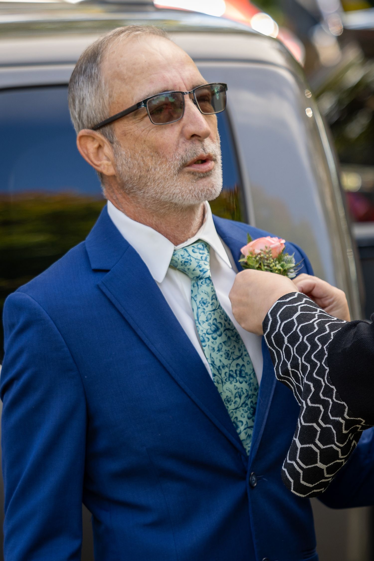 frederick maryland wedding photographer Guest in blue suit and patterned tie has boutonniere pinned to lapel.