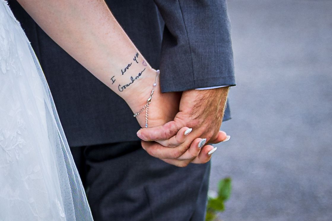 frederick maryland wedding photographer Close-up of couple holding hands showing tattoo and wedding attire.