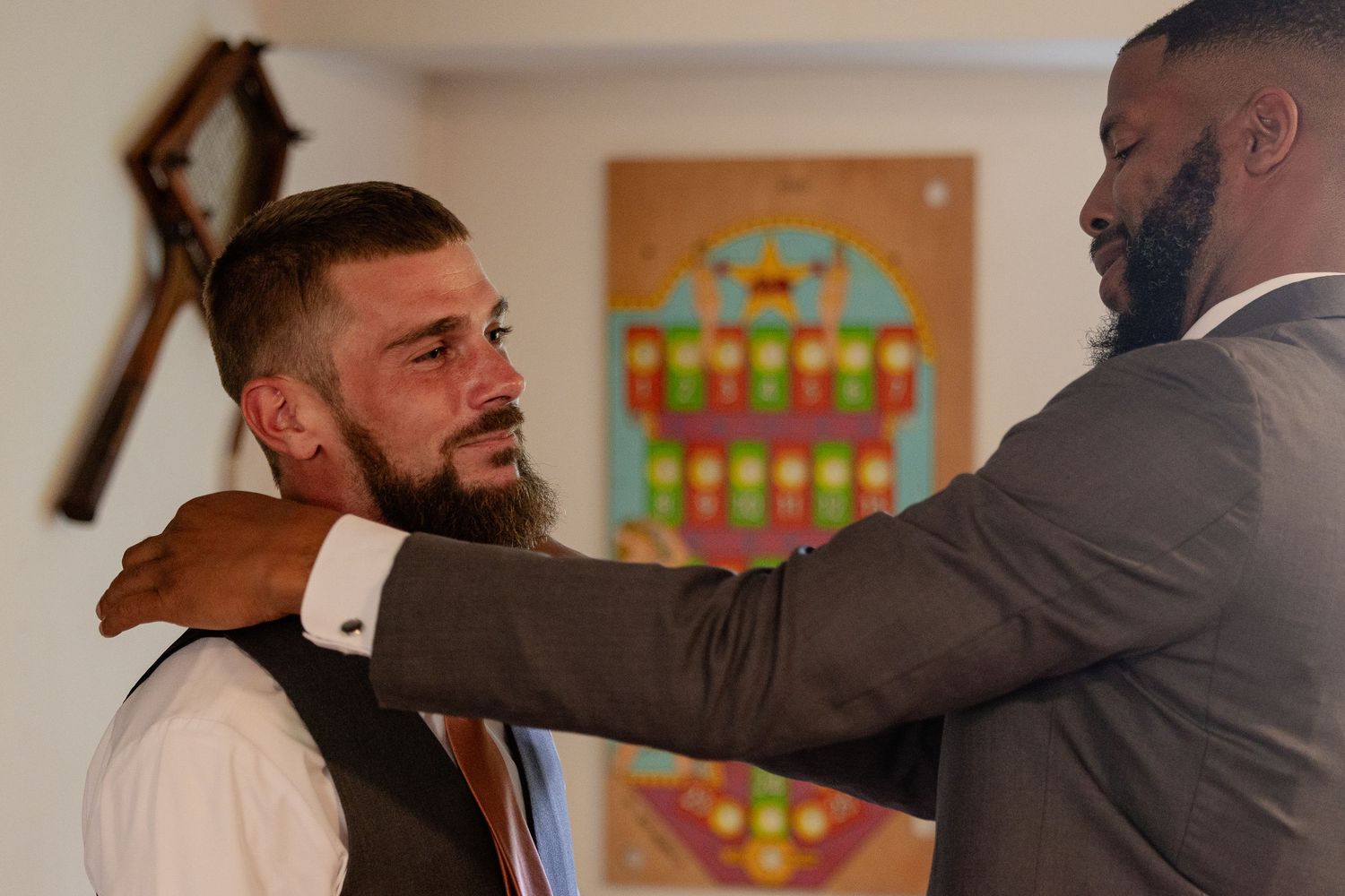 frederick maryland wedding photographer Two people in formal attire sharing an emotional moment before a colorful wall art piece.