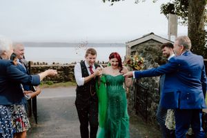 Wedding guests dance together in a line at an outdoor reception celebration.
