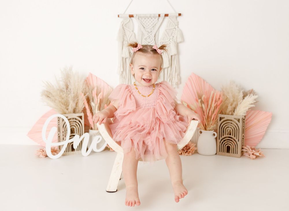 Whimsical pink tulle dress setup with decorative elements and ONE text display.