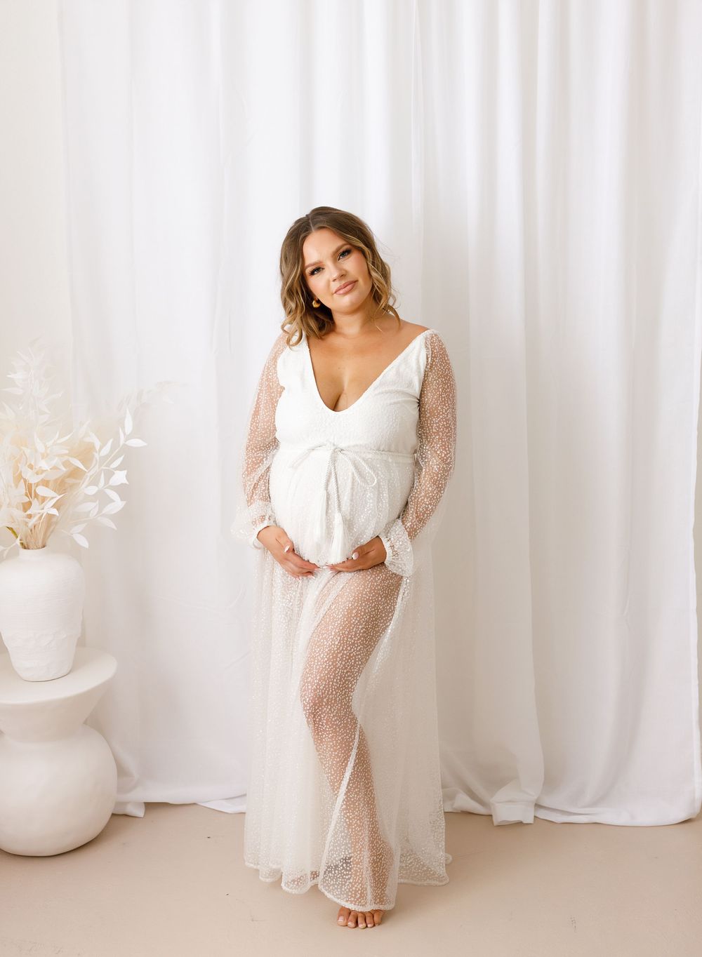 Elegant white dress portraits against soft curtain backdrop with natural lighting.