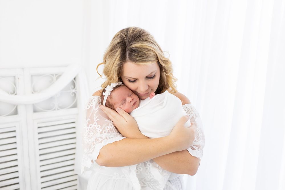 Soft white photography session with delicate lace details and natural lighting.
