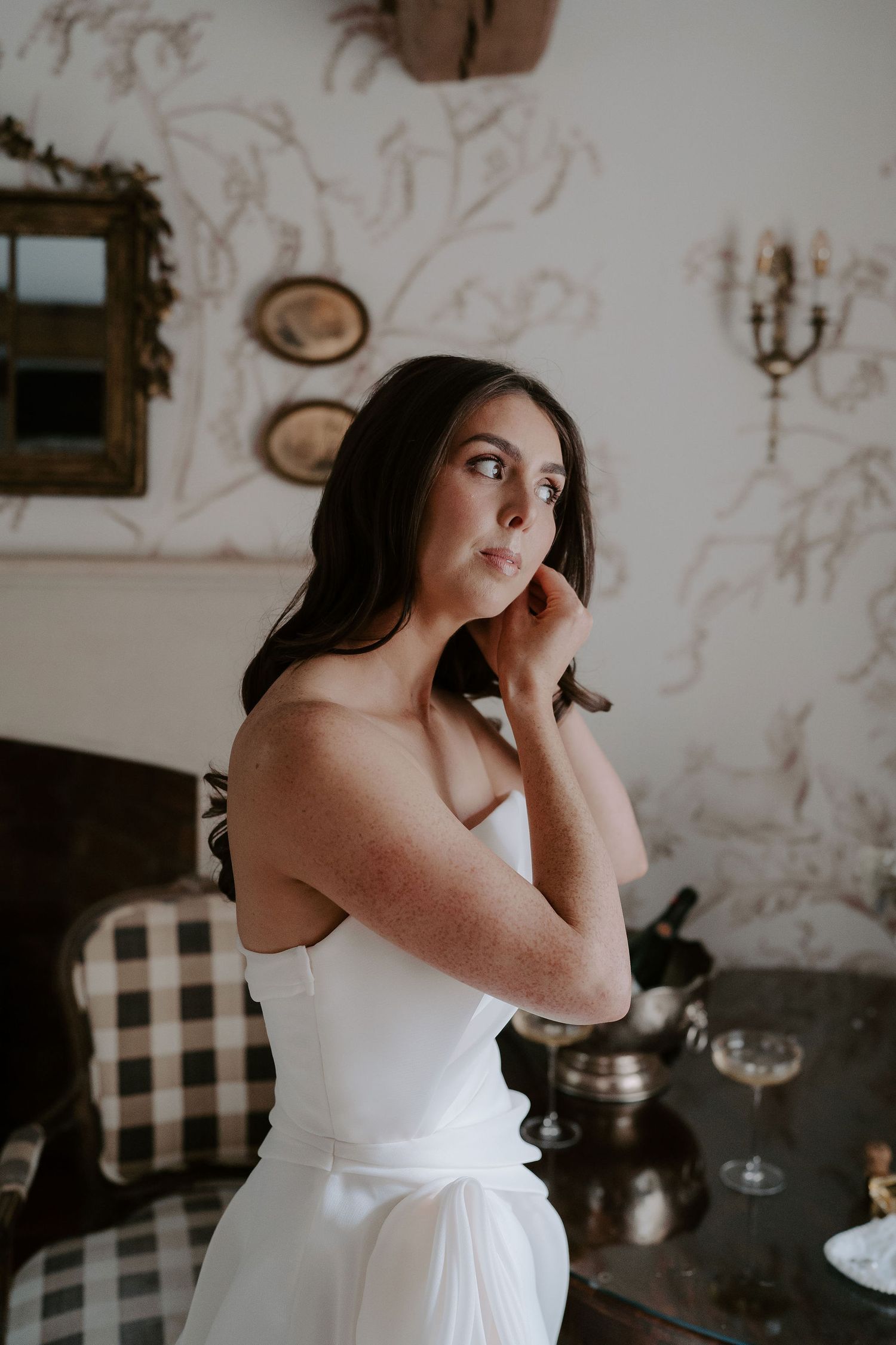 bride fastening her earrings at dewsall court in herefordshire