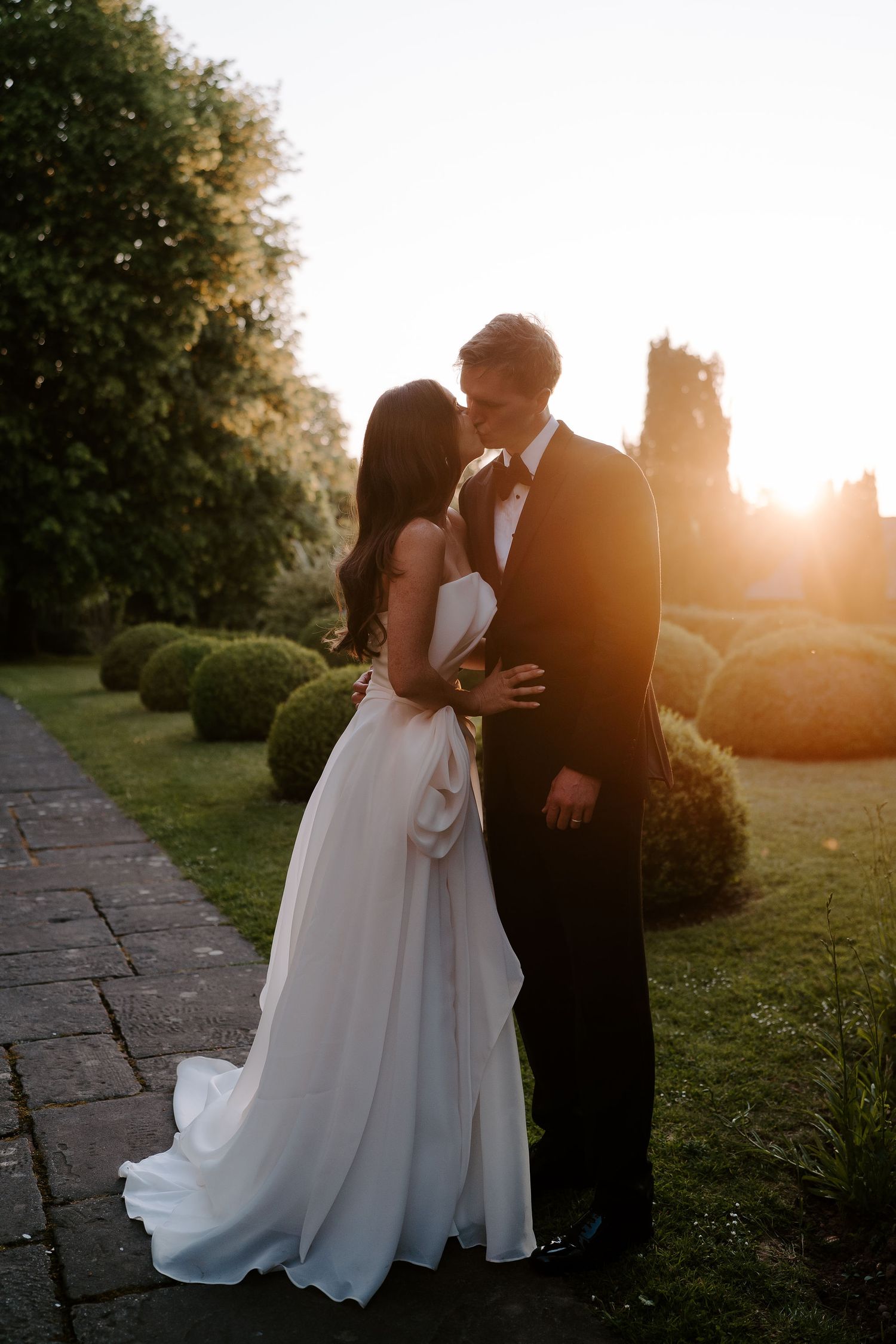 bride and groom kissing in the warm setting sun at dewsall court in herefordshire
