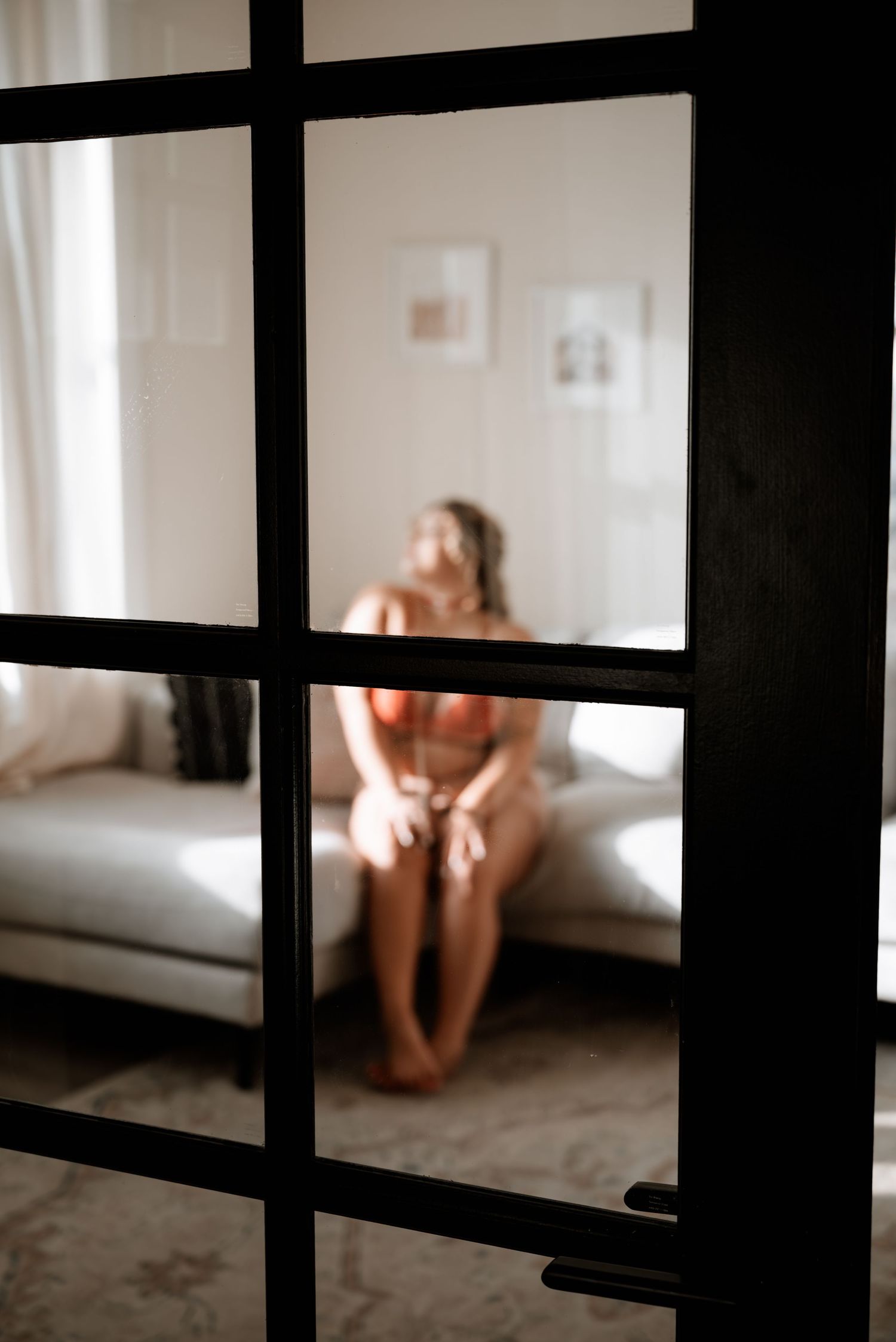 Elegant indoor boudoir portrait featuring a confident woman.