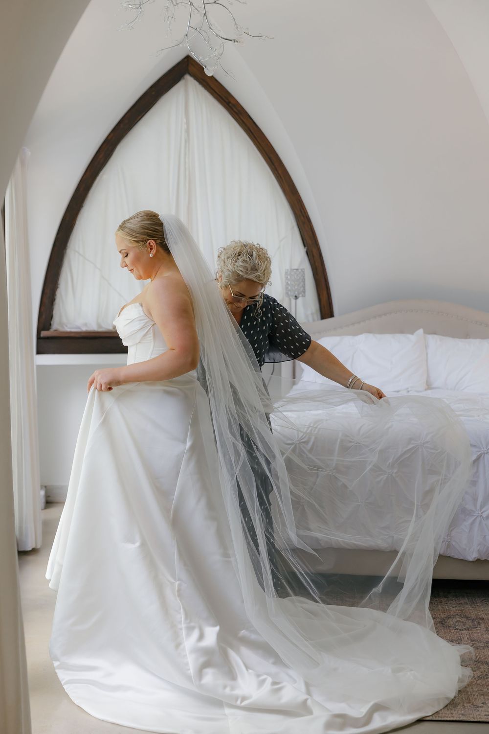 mother helps bride get ready to walk down the aisle at wedding