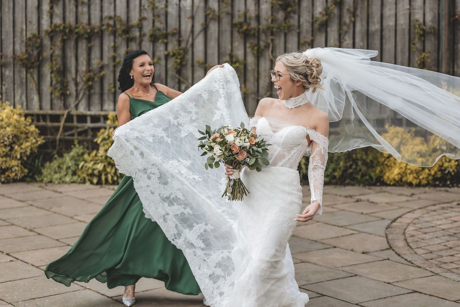 A genuine moment between bride and bridesmaid at a windy wedding day.