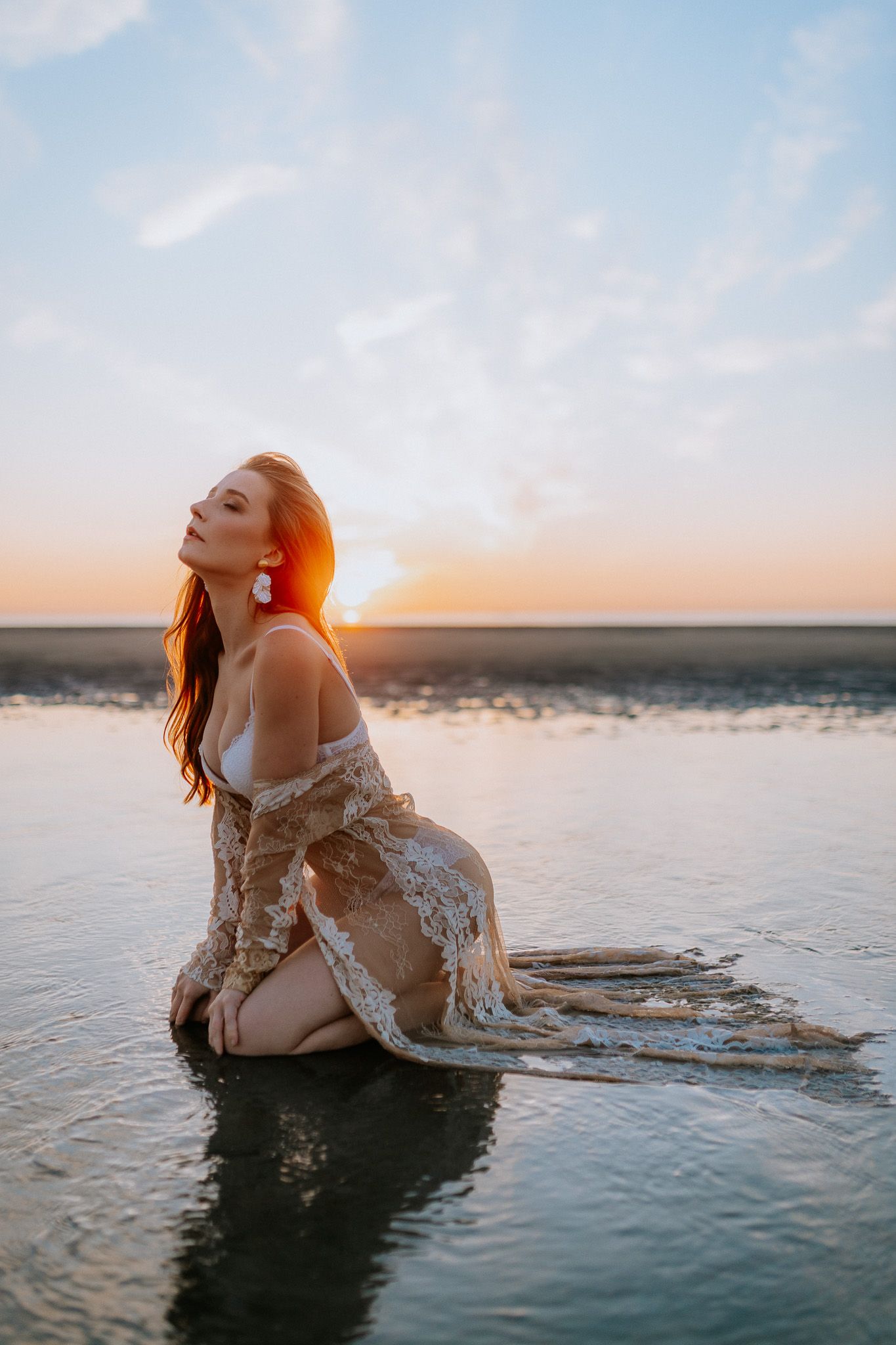 Boudoir fotografie met haar en make-up styling in Terneuzen, Zeeland, oost-Vlaanderen. Zelfverzekerde vrouw op het strand met golden hour