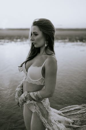 Boudoir fotografie met haar en make-up styling in Terneuzen, Zeeland, oost-Vlaanderen. Zelfverzekerde vrouw op het strand met golden hour