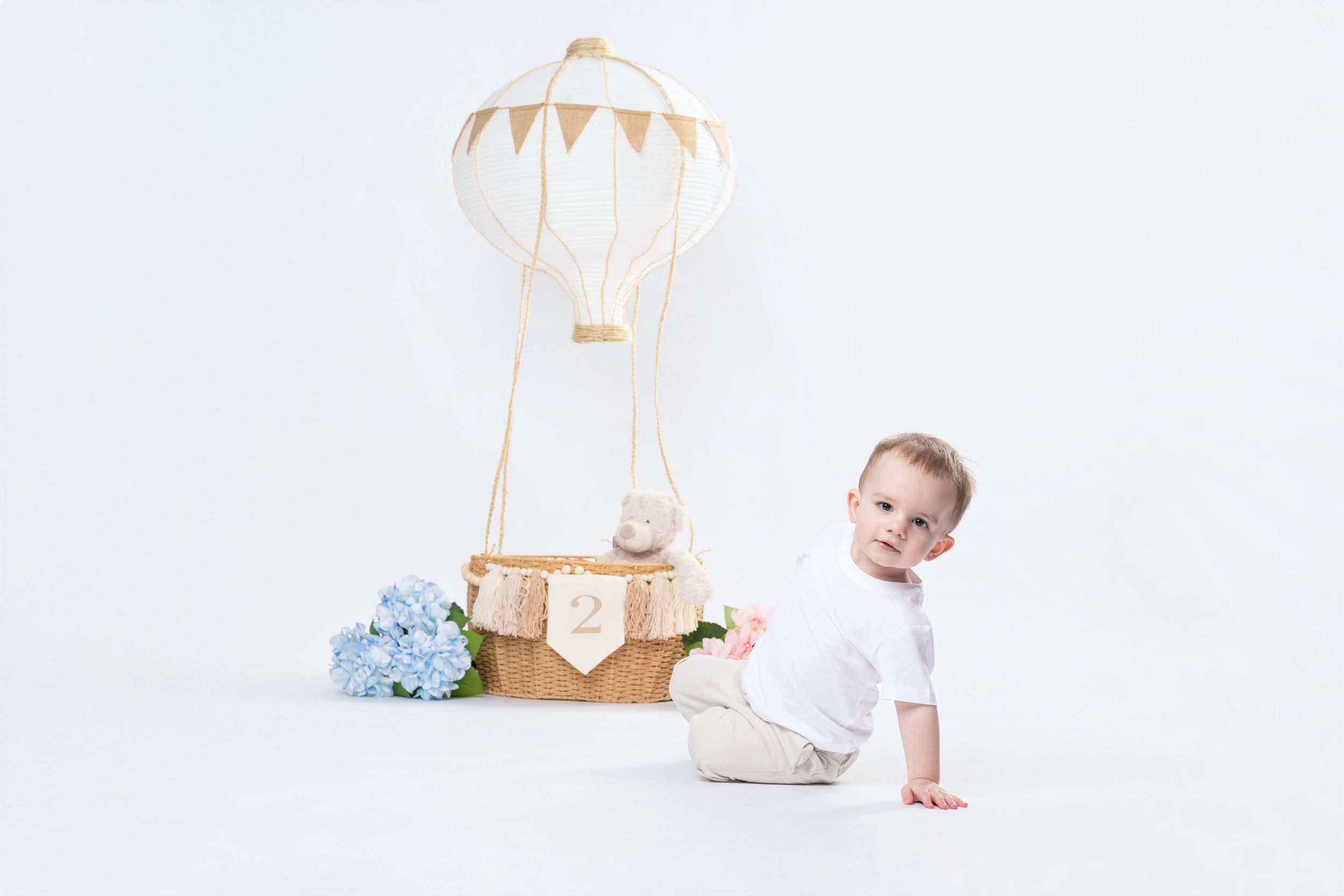 Creative second birthday portrait session with themed studio decorations.