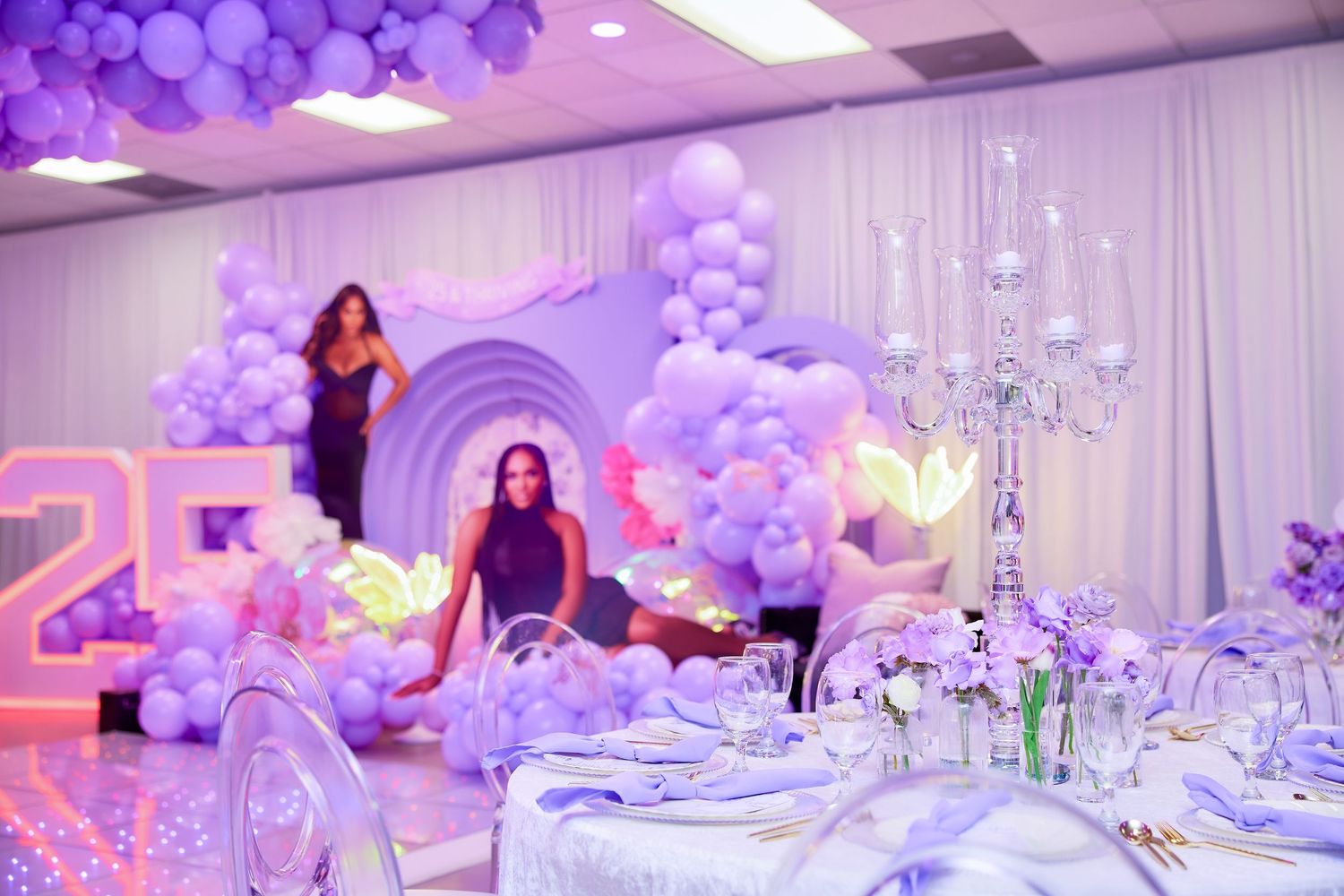 Elegant purple balloon decorated birthday party venue with number 25 display.